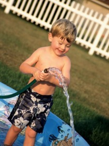 Un bambino riempie la sua piscina