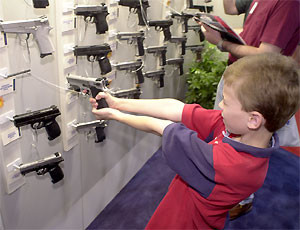 Un bimbo gioca con una pistola in negozio armi