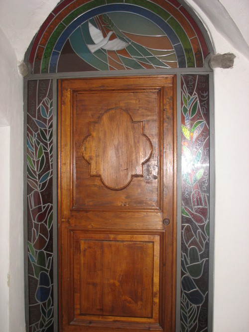 Porta della cappella della Casa per la Pace con vetrata artistica di C. Rota. " La convivialità delle differenze" - di don Tonino Bello