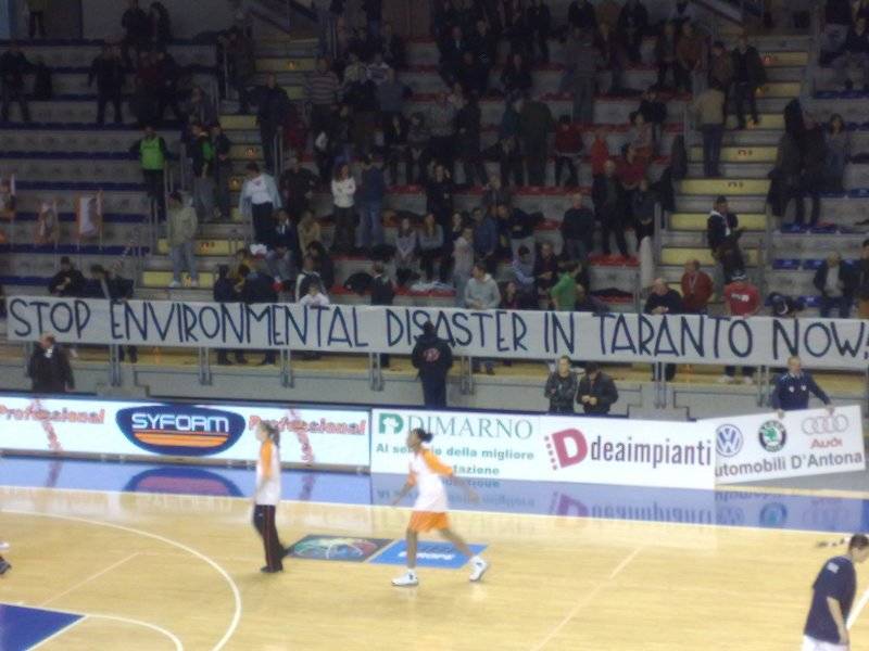 Lo striscione con la scritta in inglese "Ferma il disastro ambientale a Taranto ora"