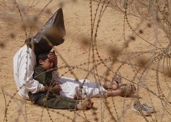 Jean-Marc Bouju France, The Associated Press Iraqi man comforts his son at a regroupment center for POWs, Najaf, Iraq, 31 March 