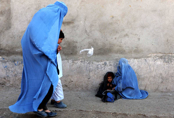 Una donna afgana con il suo bambino chiedono l'elemosina nella città di Herat. La situazione delle donne afgane è preoccupante.