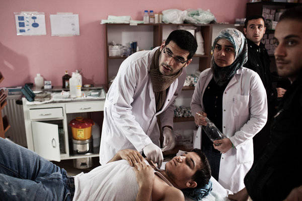 Il Dottor Housam Moustafa, un medico tirocinante, cura un ribelle siriano nella clinica di Reyhanli, in Turchia.