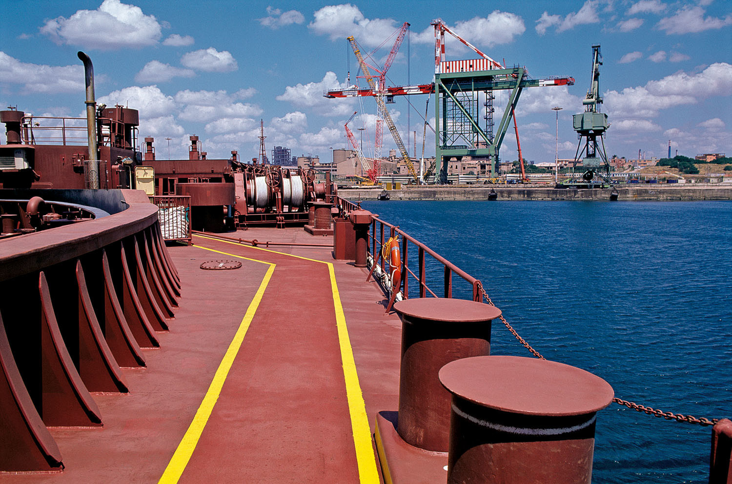 La foto mostra la banchina del porto utilizzata dall'ILVA per lo scarico delle materie prime che si depositano liberamente ovunque.