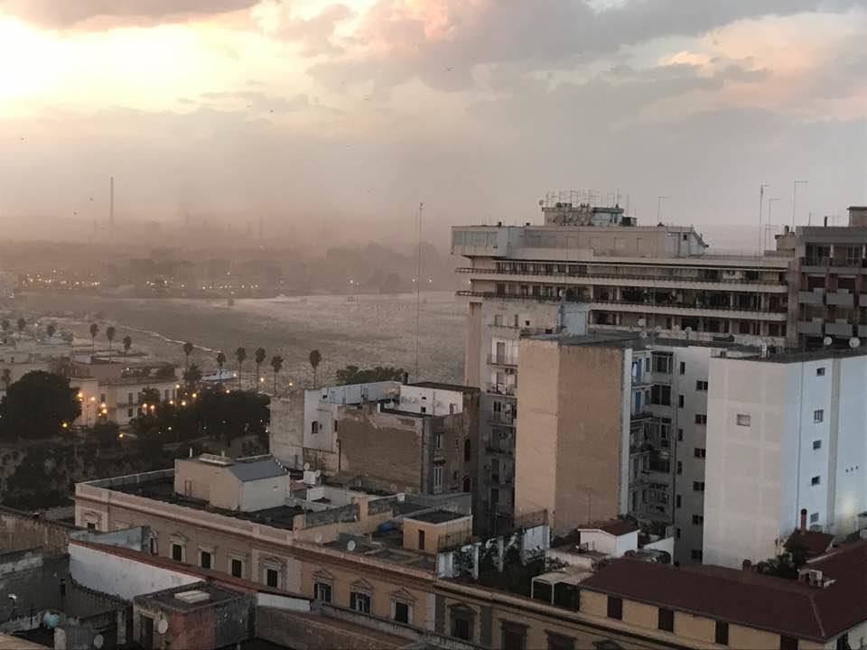 12 agosto 2017, la città di Taranto ed in particolare il quartiere Tamburi vengono coperti dalle polveri provenienti dall’area industriale. Immagine scattata dal Borgo.