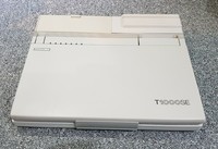 Il primo computer di PeaceLink, leggero (2,5 kg) e con grande autonomia (4 ore); era una "redazione portatile" con cui raccogliere appunti nelle riunioni pacifiste. Lo schermo era monocromatico. Il software di collegamento telematico era il Telix.