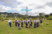 Equipaggiate con cinture e imbracature di sicurezza, le prime apprendiste si riuniscono intorno agli istruttori per ascoltare un discorso motivazionale prima di cominciare l’addestramento.