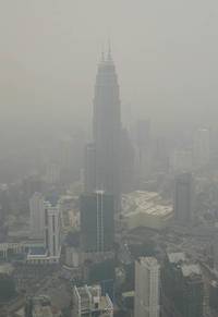 TORRI NELLA NEBBIA Le Petronas towers (sullo sfondo), nella capitale della Malaysia Kuala Lumpur, immerse nella foschia. Il fumo arriva dalla vicina Indonesia dove per settimane sono bruciati senza controllo ettari di piantagioni di palme da olio e di cam