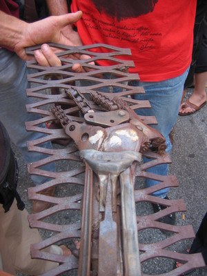 Genova, 20 luglio 2004, piazza Alimonda.  Una scultura in ferro depositata sulla grata della chiesa di Nostra Signora del Rimedio dopo la morte di Carlo Giuliani. Dopo alcuni atti di vandalismo, la sc
