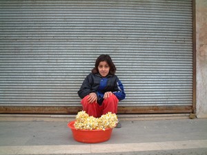 Bambina curda vende fiori all'angolo della strada