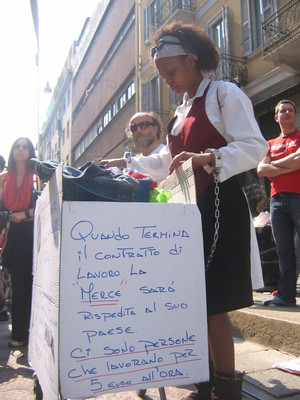 Una manifestante cilena vende bicchieri di vino durante il corteo mostrando un cartello con la scritta "quando termina il contratto di lavoro, la merce sara' rispedita al suo paese. Ci sono persone ch
