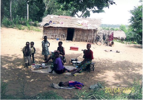 Scena di convivialità. La mamma sta preparando il pranzo ("luku" a base di manioca) che consumeranno seduti sulla stuoia.