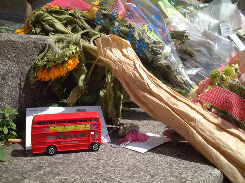 Un modellino di autobus insieme a dei fiori lasciati vicino Tavistock Square