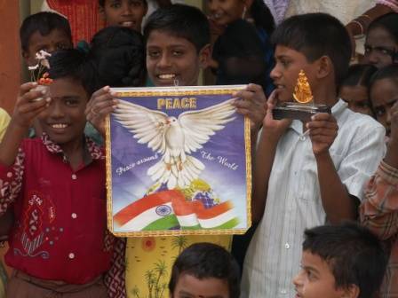 i ragazzi si sono messi in posa esibendo il loro desiderio di pace: la colomba abbraccia il mondo con le ali e la bandiera indiana sembra abbracciarlo.