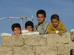 Bambini si affacciano in un villaggio verso Kirkuk.