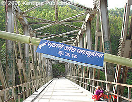 Lo striscione indica 'check point per tutti i veicoli – Area sotto il controllo del governo popolare Maoista': i ribelli Maoisti hanno costruito una barricata sul ponte Tamakoshi lungo la strada Lamosanghu-Jiri per raccogliere pedaggi dai veicoli. 